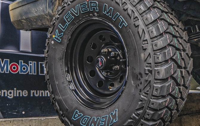 Kenda tyres mounted on black vehicle, showing durable tread for superior grip and performance